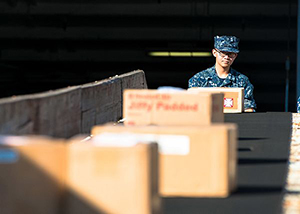 Logistics Specialist Seaman Miguel Torres, from San Diego, unloads cargo from a conveyor belt onto the enlisted quarterdeck of the aircraft carrier USS John C. Stennis (CVN 74). John C. Stennis is in port training for future deployments. (U.S. Navy photo by Mass Communication Specialist 3rd Class Andre T. Richard/Released) 