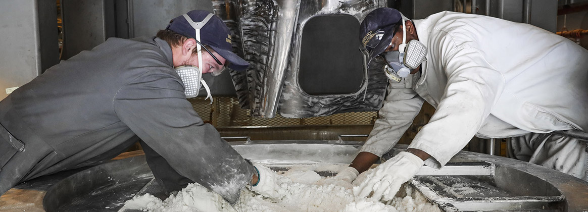 Naval Surface Warfare Center Indian Head Division Energetics Manufacturing Department’s Explosives and Energetics Division operators screen energetic material at the 420 Gallon Mixer. 