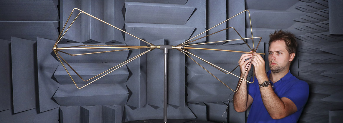 Naval Surface Warfare Center Indian Head Division Electronic Protection Systems Branch Electronics Engineer Sean Bednarek assembles a biconical antenna for a gain measurement in the Explosive Ordnance Disposal Department’s Anechoic Chamber. 