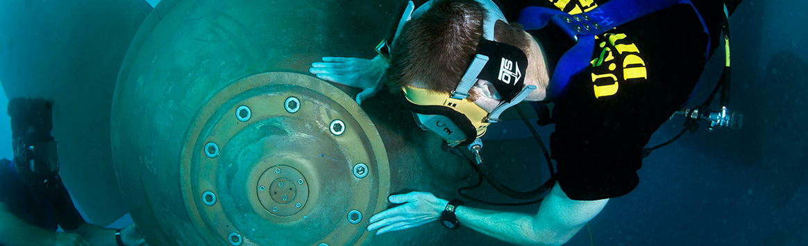 Lt. Cmdr. Taylor South, right, assigned to Forward Deployed Regional Maintenance Center (FDRMC), and Kevin Eppleman, a civilian diver assigned to Mid-Atlantic Regional Maintenance Center (MARMC), conduct a propeller inspection on the Ticonderoga class-guided-missile cruiser USS Hue City (CG 66)