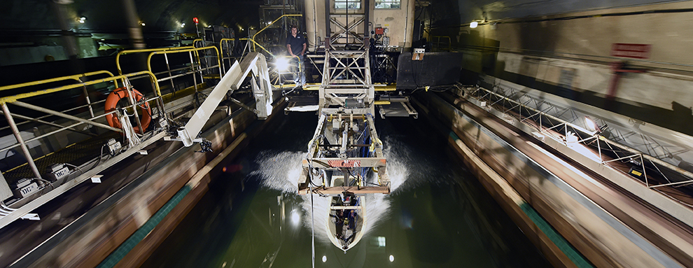 A ship hull model attached to a high-speed sled moves through waves at the Naval Surface Warfare Center (NSWC) Carderock's David Taylor Model Basin. 