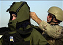 Service member helping put an EOD suit on another service member