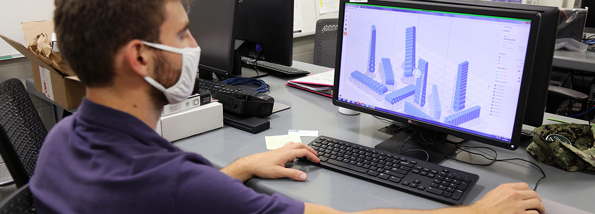 Engineering Technician Adrian Wos reviews 3D models of potential Fiber Optic Sensing System (FOSS) housing units