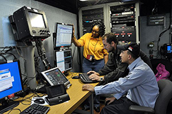 Fran White, left, a civil service employee at Space and Naval Warfare Systems Command, Systems Center Atlantic, and Clayton Bush, a Tactical Networks (PMW-160) contractor, work with Information Systems Technician 2nd Class James Rago to troubleshoot the video teleconference system of a video information exchange system aboard the aircraft carrier USS Ronald Reagan (CVN 76). PMW-160 and SPAWAR provide the Navy with network fabric and services used by multiple shipboard tactical and business applications and systems and routinely install, maintain and train crewmembers in operational and maintenance procedures. (U.S. Navy photo by Rick Naystatt/Released)