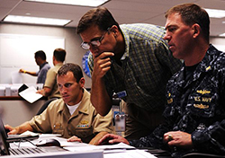 Lt. Cmdr. Gregg Bento, left, assigned to Commander, Navy Region Hawaii (CNRH), Shawn Morrissey, CNRH deputy of Operations, and Capt. John Polowczyk, commanding officer of Fleet and Industrial Supply Center Pearl Harbor, provide logistics support during the region operations center's Liberty Champion exercise. Liberty Champion is a simulated emergency management exercise that tests the Navy's rapid responses during crisis situations such as hurricane, earthquakes and oil spills. (U.S. Navy photo by Mass Communication Specialist 2nd Class Mark Logico/Released)