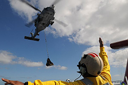 Black Knights of Helicopter Anti-Submarine Squadron (HS) 4 to lower supplies sent from the aircraft carrier USS Ronald Reagan (CVN 76) onto the weather deck of the Carnival cruise ship C/V Splendor. Ronald Reagan was diverted from its training maneuvers at the direction of Commander, U.S. Third Fleet, and at the request of the U.S. Coast Guard, to a position near the Carnival cruise ship C/V Splendor. Ronald Reagan is facilitating the delivery of 4,500 pounds of supplies to CV Splendor after the cruise ship became stranded 150 nautical miles southwest of San Diego early Monday. (U.S. Navy photo by Mass Communication Specialist 3rd Class Kevin Gray/Released) 