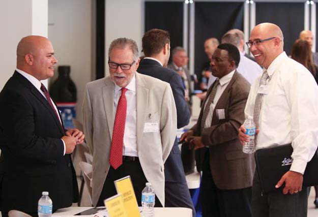 NSWC Corona's Thomas Beauchamp (left) talks to visitors at a Corona University event