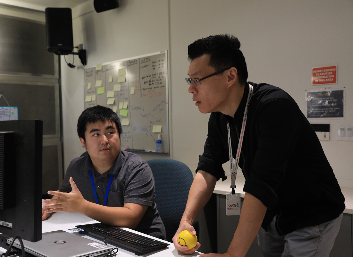 NSWC Corona personnel discuss the details of the application they have in development