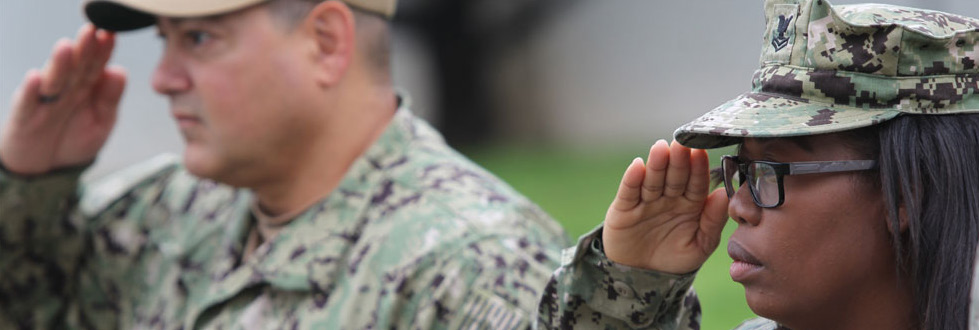 Navy sailors salute the American flag during colors