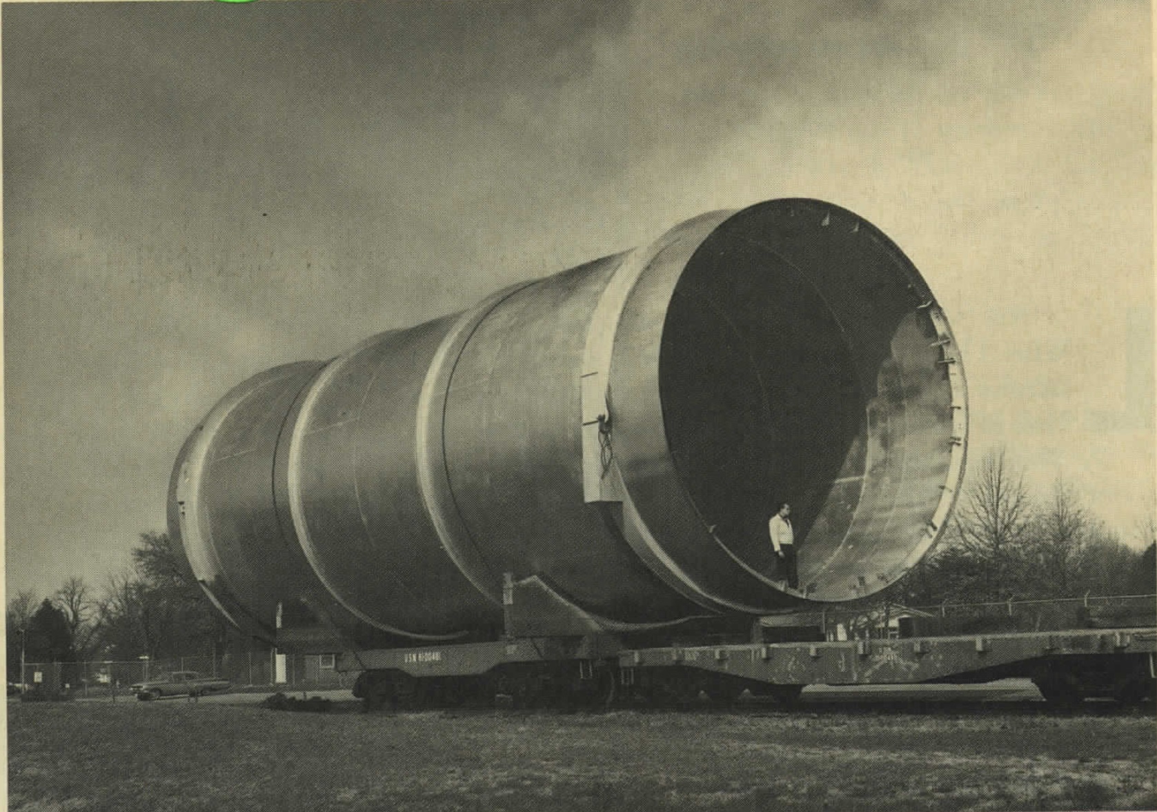 A man stands in the muzzle of the conical shock tube during construction, c. 1967
