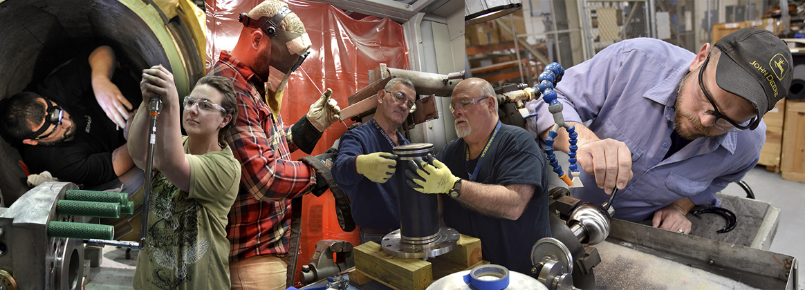 Workers inspecting, welding, and performing work